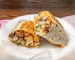 A burrito cut open, filled with rice, beans and grilled meat