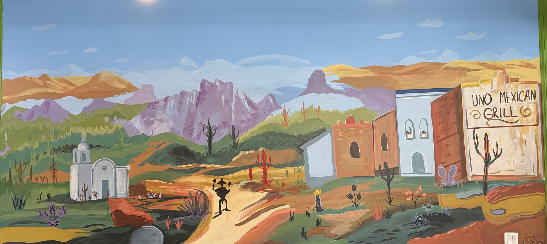 The hand-painted desert mural in the dining room, with a painted sign reading UNO Mexican Grill